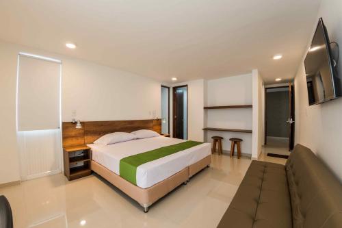a bedroom with a bed and a flat screen tv at Altoprado Popayán in Popayan