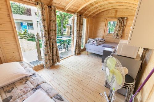 Cette petite chambre comprend un canapé et une table. dans l'établissement Camping de Tournus - Drole de cabane, à Tournus