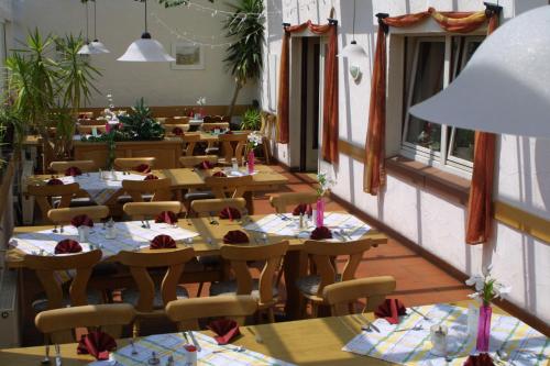un ristorante con tavoli e sedie in una stanza di Spessarter Hof a Hobbach