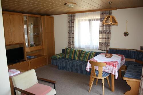 a living room with a couch and a table at Haus Rosenauer Zimmer & Ferienwohnungen in Nussdorf am Attersee