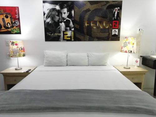 a bedroom with a white bed and two lamps at Spazio Boutique Hotel in Cancún