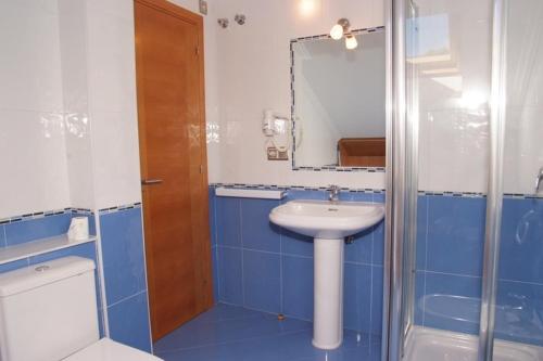 a blue and white bathroom with a sink and a shower at Apartamentos Ay Sálvora in O Grove