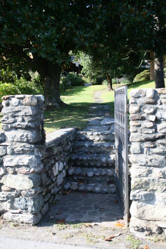 a gate in a stone wall with a fence at Agriturismo Badalone in Domaso