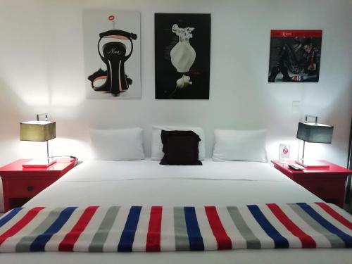 a bedroom with a large white bed with two lamps at Spazio Boutique Hotel in Cancún