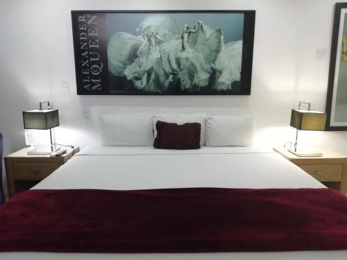 a bedroom with a large white bed with two lamps at Spazio Boutique Hotel in Cancún
