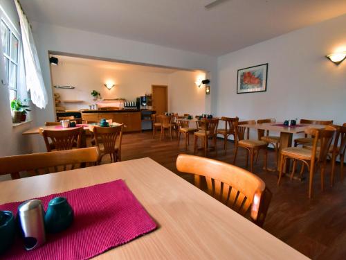 uma sala de jantar com mesas e cadeiras num restaurante em Landhauspension Rank em Bad Berka