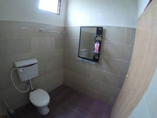 mała łazienka z toaletą i lustrem w obiekcie Homestay Tok Abah Kuala Besut w mieście Kuala Besut
