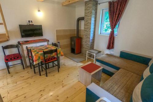 a living room with a table and a couch and a tv at Small Montenegro in Žabljak