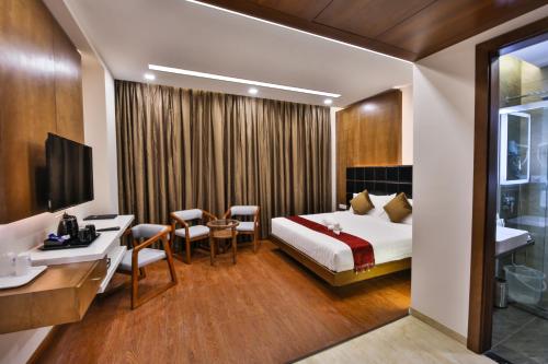um quarto de hotel com uma cama e uma secretária em The Royal Grand em Karūr