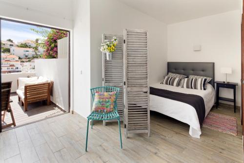 sypialnia z łóżkiem, krzesłem i biurkiem w obiekcie Casino 4 w mieście Carvoeiro