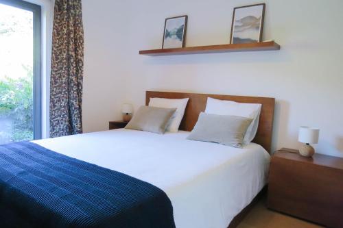 een slaapkamer met een groot wit bed en een raam bij Casa da Mouta - Douro Valley in Baião