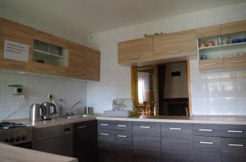 uma cozinha com armários de madeira e um lavatório em Pensjonat u Kowala em Wałcz