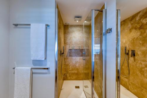 a bathroom with a shower with a glass door at La Playa Orient Bay in Orient Bay