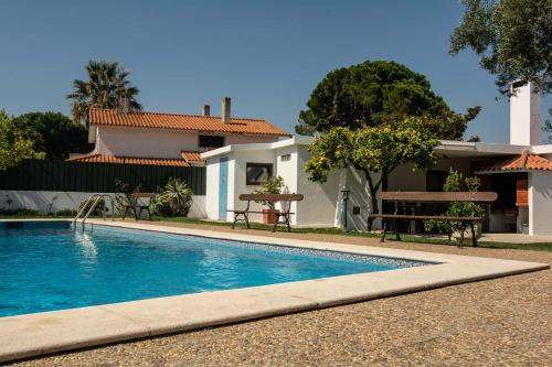 a swimming pool in front of a house at Casa da Quintinha - Villa with a pool in Sesimbra