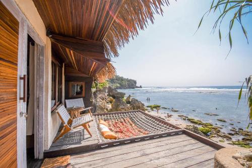 a house with a balcony with a view of the ocean at Le Cliff Bali in Uluwatu