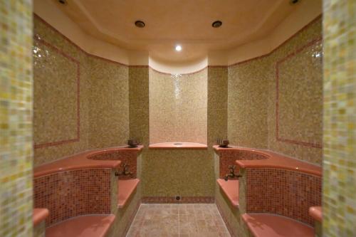 a bathroom with pink tables and chairs in it at Hotel Landhaus Wachtelhof in Rotenburg an der Wümme