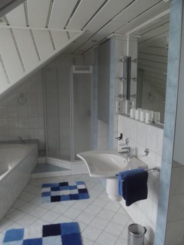 La salle de bains est pourvue d'un lavabo, de toilettes et d'une baignoire. dans l'établissement Ferienwohnung in Puschendorf, à Puschendorf