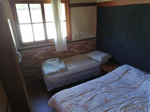 a small bedroom with a bed and a window at centro piria apartamento 4 in Piriápolis