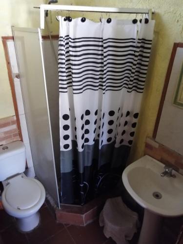 a bathroom with a black and white shower curtain and a toilet at centro piria apartamento 4 in Piriápolis