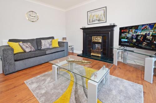 a living room with a couch and a fireplace at The Croft, North Staffordshire in Blythebridge