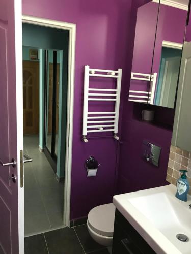a purple bathroom with a toilet and a sink at Apartament Langa Plaja Diana in Mangalia