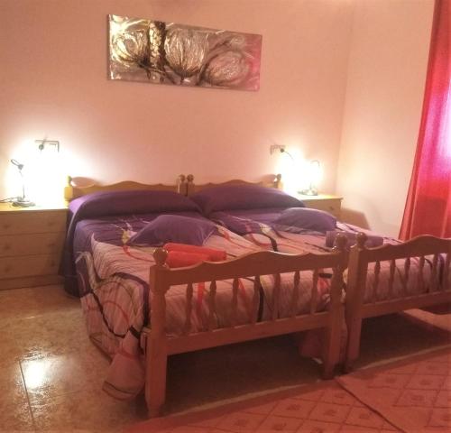 a bedroom with a wooden bed with two lamps at Casa Rural El Cerrete 2 in Riópar