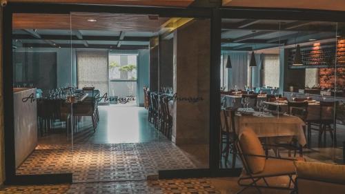 a restaurant with tables and chairs in a room at Annaya Suítes in Viçosa