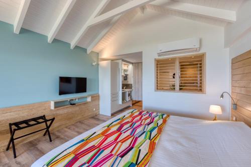 a bedroom with a large bed with a colorful blanket at La Playa Orient Bay in Orient Bay