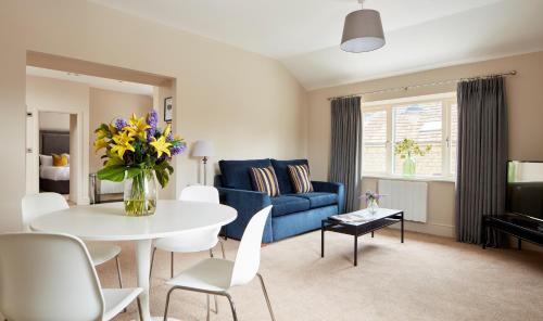 a living room with a blue couch and a table at Rooms by Bistrot Pierre at The Crescent Inn in Ilkley