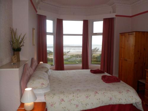 a bedroom with a bed with a view of the ocean at Wavecrest Lodge in Fleetwood