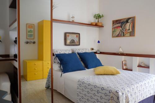 Schlafzimmer mit einem Bett mit blauen und gelben Kissen in der Unterkunft A casa di Andrea e Lucia in Gaeta