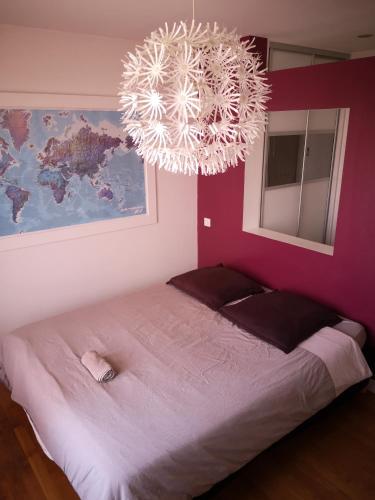 une chambre avec un grand lit et un lustre dans l'établissement Le balcon de l'Aigle, à Grenoble