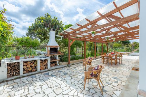 a patio with a fireplace and a table and chairs at Chitaka's Organic Farmhouse in Ribatejo in Santo Estêvão