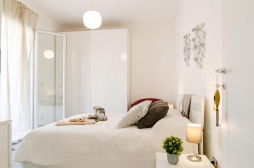 Un dormitorio blanco con una cama y una ventana. en FCO Luxury Apartments, en Fiumicino