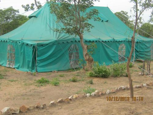 a blue tent with a tree in front of it at Lochinvar Safari Lodge of Lochinvar National Park - ZAMBIA in Lochinvar National Park