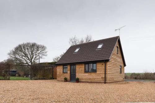 a small wooden house with a black roof at Coach House in Milton Keynes