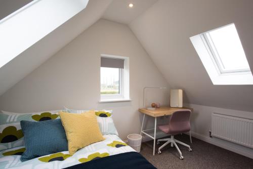 a bedroom with a bed and a desk at Coach House in Milton Keynes