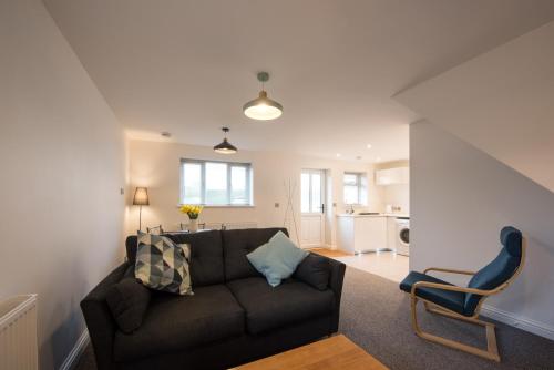 a living room with a couch and a chair at Coach House in Milton Keynes