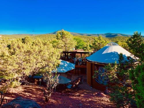 Jurte mit Tisch und Stühlen auf einem Feld in der Unterkunft The Yoga Yurta at Sunny Mellow Eco Villa in Tijeras