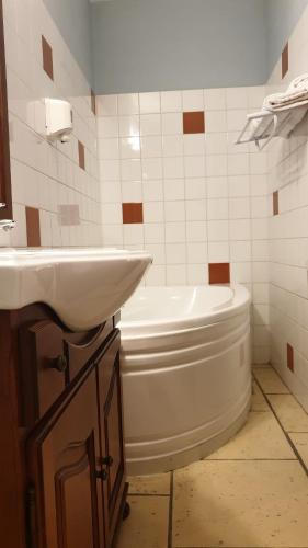 une salle de bain avec un lavabo, une baignoire et des toilettes dans l'établissement L'ALCOVE HOTEL RESTAURANT, à Villematier