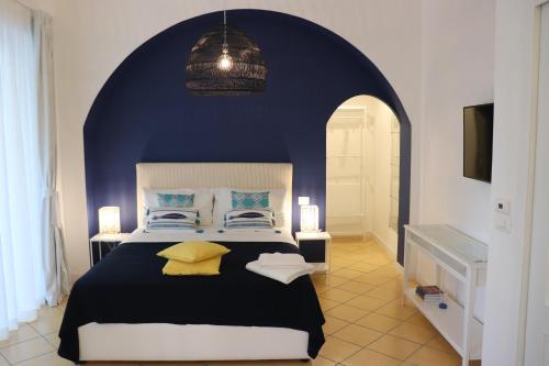 ein Schlafzimmer mit einem großen Bett mit blauer Wand in der Unterkunft Lemon Suite in Neapel
