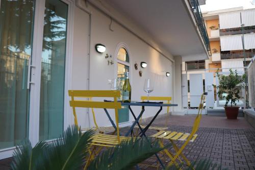 a patio with two yellow chairs and a table at Lemon Suite in Naples