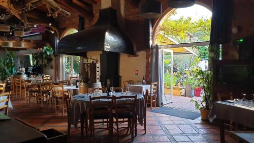 un ristorante con tavoli e sedie e una grande finestra di L'ALCOVE HOTEL RESTAURANT a Villematier