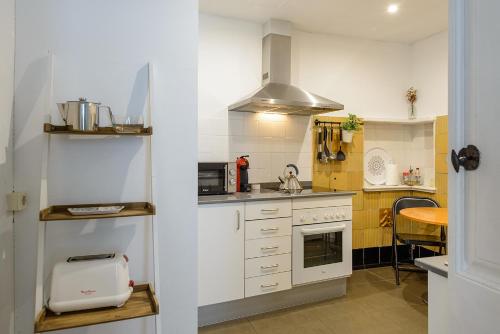 a kitchen with white cabinets and a stove top oven at APG Espais Rambla in Girona