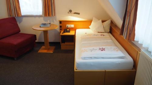 um quarto com uma cama, uma cadeira e uma mesa em BB City Hotel em Böblingen