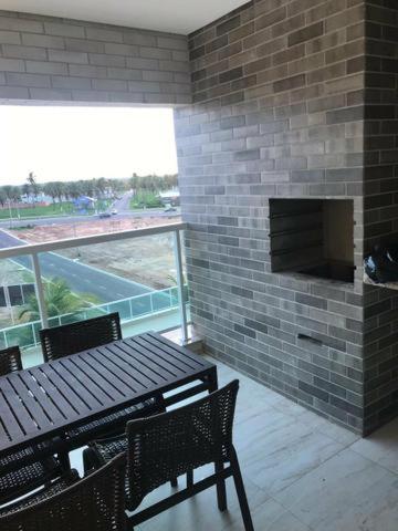 a balcony with a table and chairs and a brick wall at S&F apartamentos em Salinas Park, Exclusive ou Premiun in Salinópolis