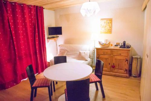 - une table et des chaises dans une pièce avec rideau rouge dans l'établissement Appartement 5 personnes - 38860 Les 2 Alpes - Pied des pistes, balcon, à Les Deux Alpes