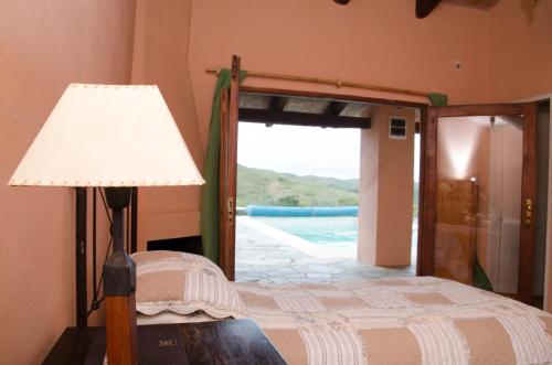 una camera con letto, lampada e porta di RINCON DE LOS MATREROS a Isla Patrulla