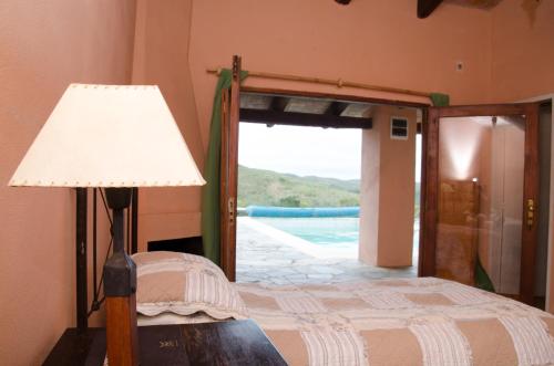 a bedroom with a bed and a lamp and a door at RINCON DE LOS MATREROS in Isla Patrulla