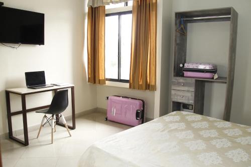 a bedroom with a bed and a pink suitcase at Hotel Varadero Internacional in Guayaquil